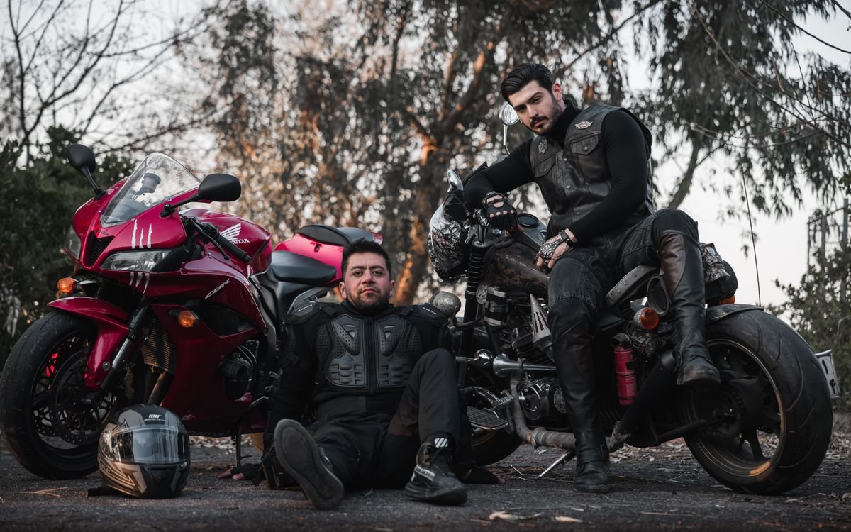 Motociclisti in pelle accanto a una moto classica