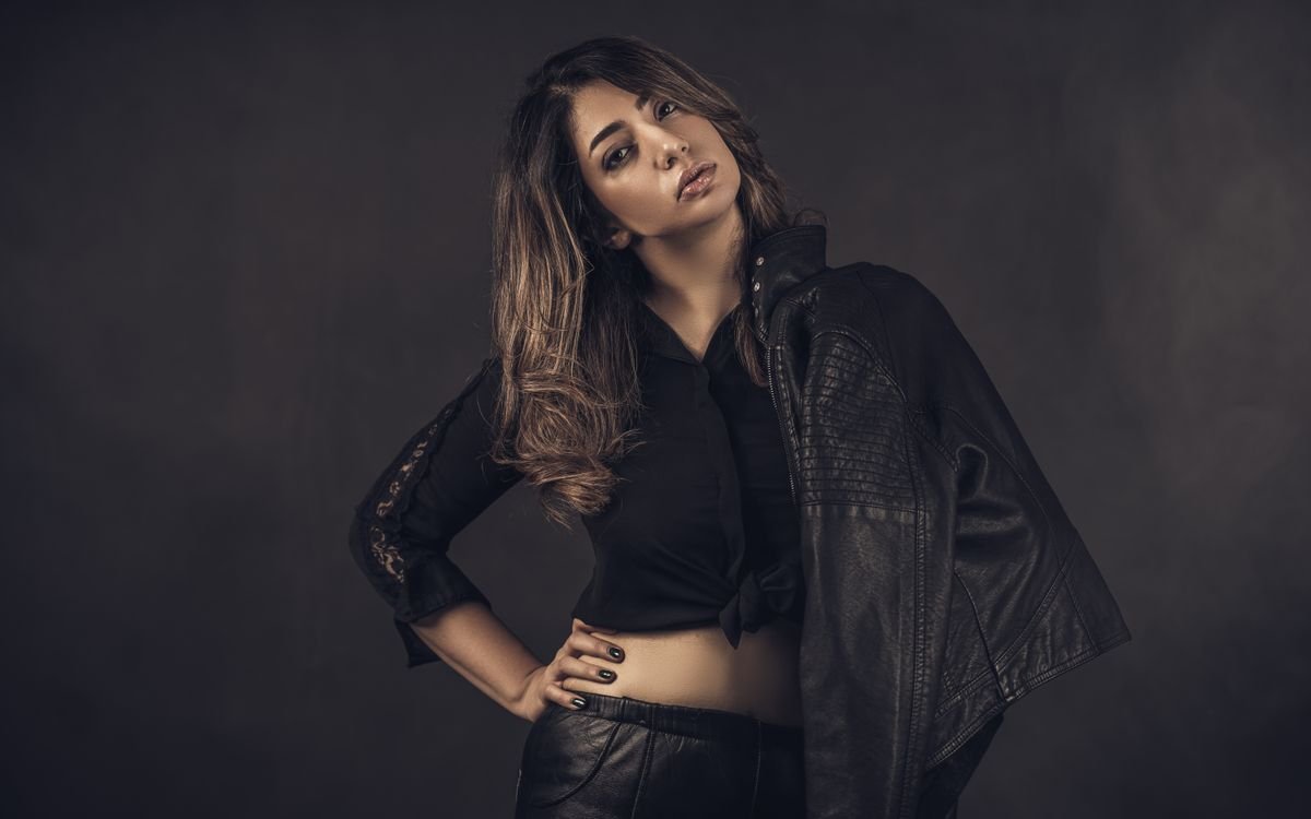 Donna elegante in una liscia giacca di pelle nera, ritratto in studio dall atmosfera sobria