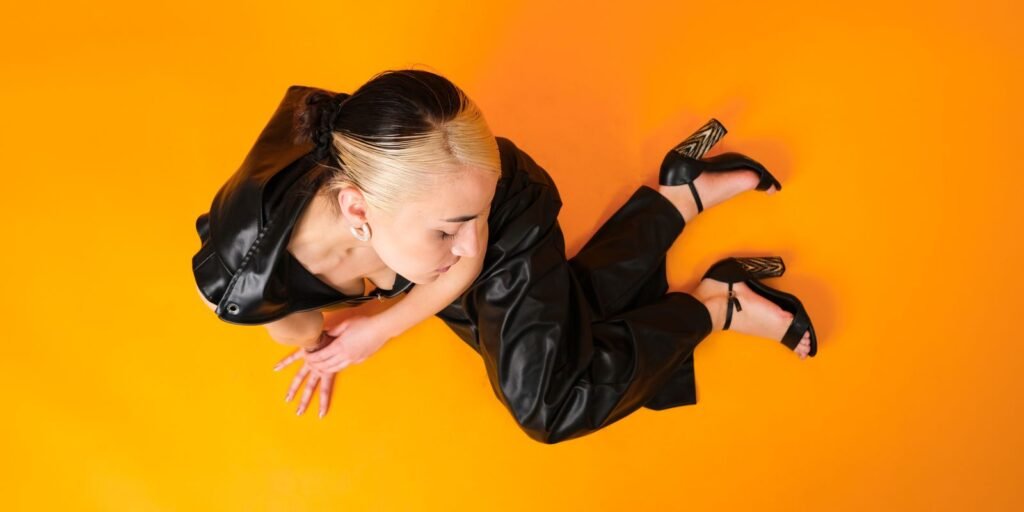 Una modella in pelle nera su un fondale di studio deciso