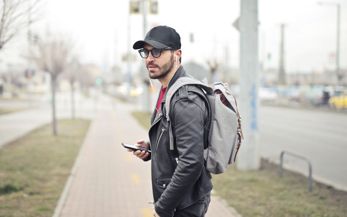 Giovane uomo elegante a Budapest che controlla lo smartphone in una strada trafficata
