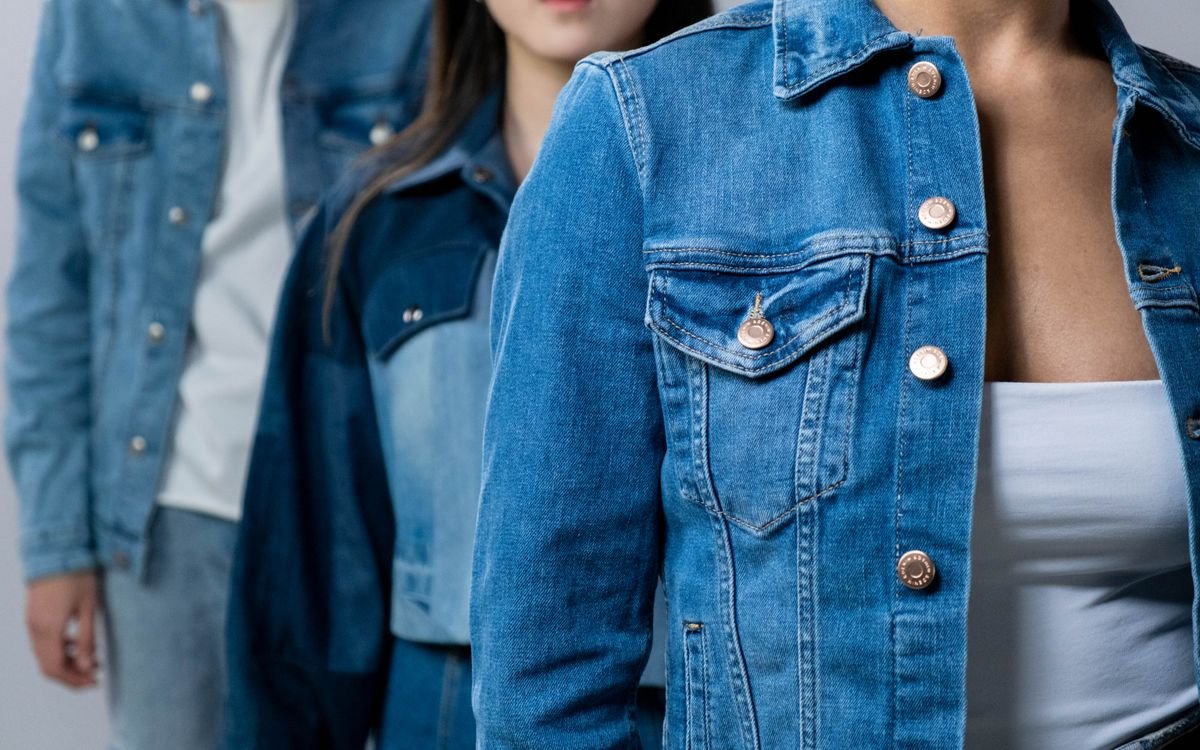 Group of people modeling stylish denim jackets in studio setting