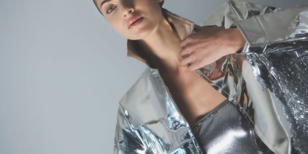 Modella in un look argento e futuristico sotto la luce dello studio