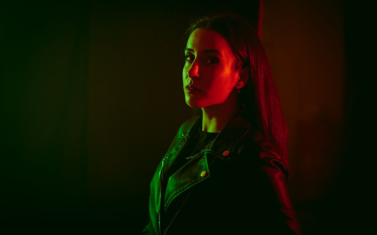 Ritratto in studio dall atmosfera sobria di una donna in giacca di pelle nera
