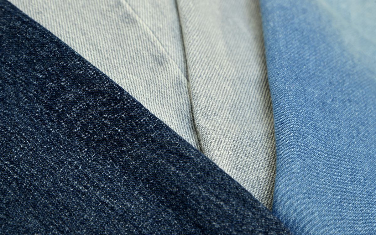 Primo piano di un tessuto denim blu che mostra la texture e le cuciture