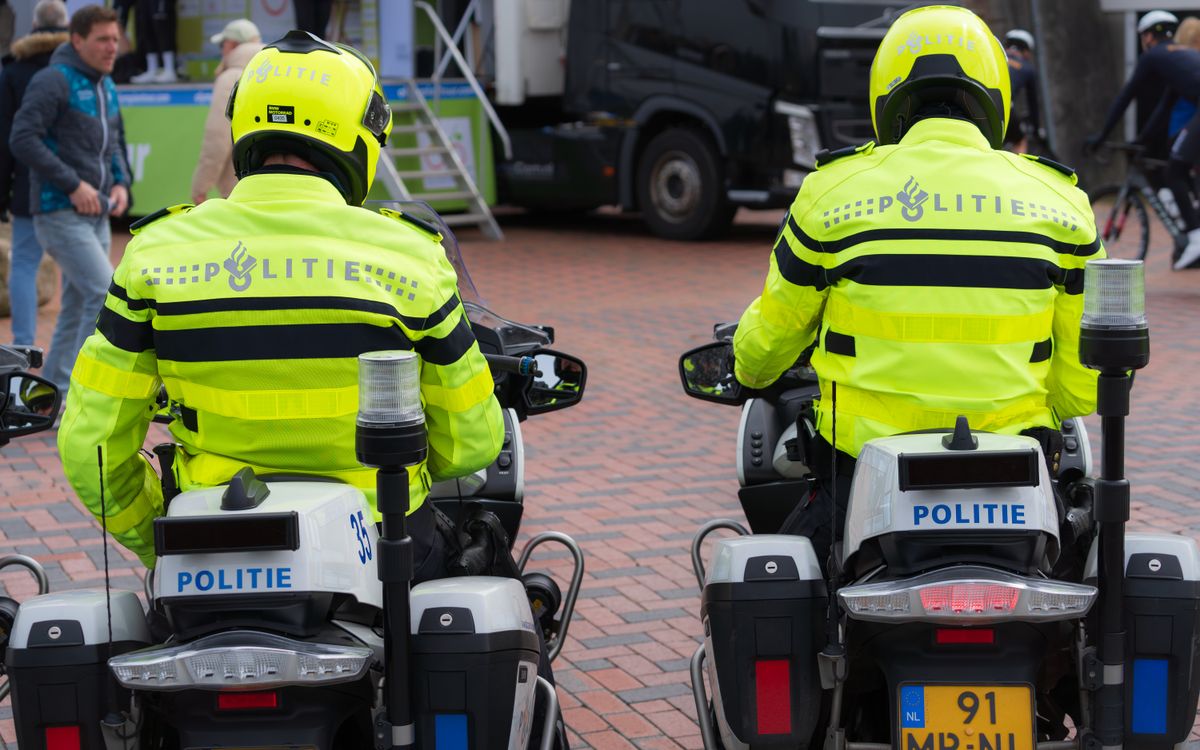 Due poliziotti in uniforme chiara pattugliano un evento pubblico in moto
