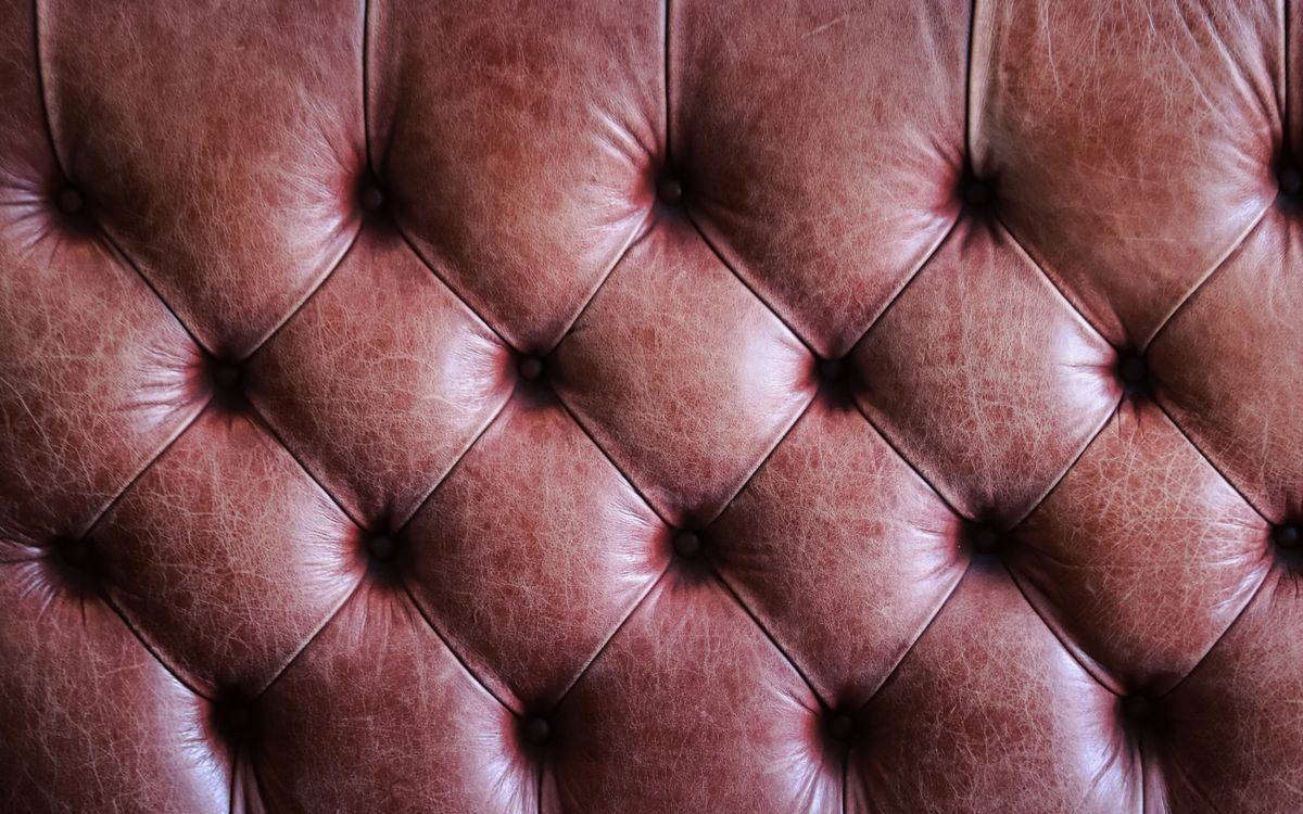 Primo piano di un rivestimento in pelle marrone capitonné dalla texture vintage
