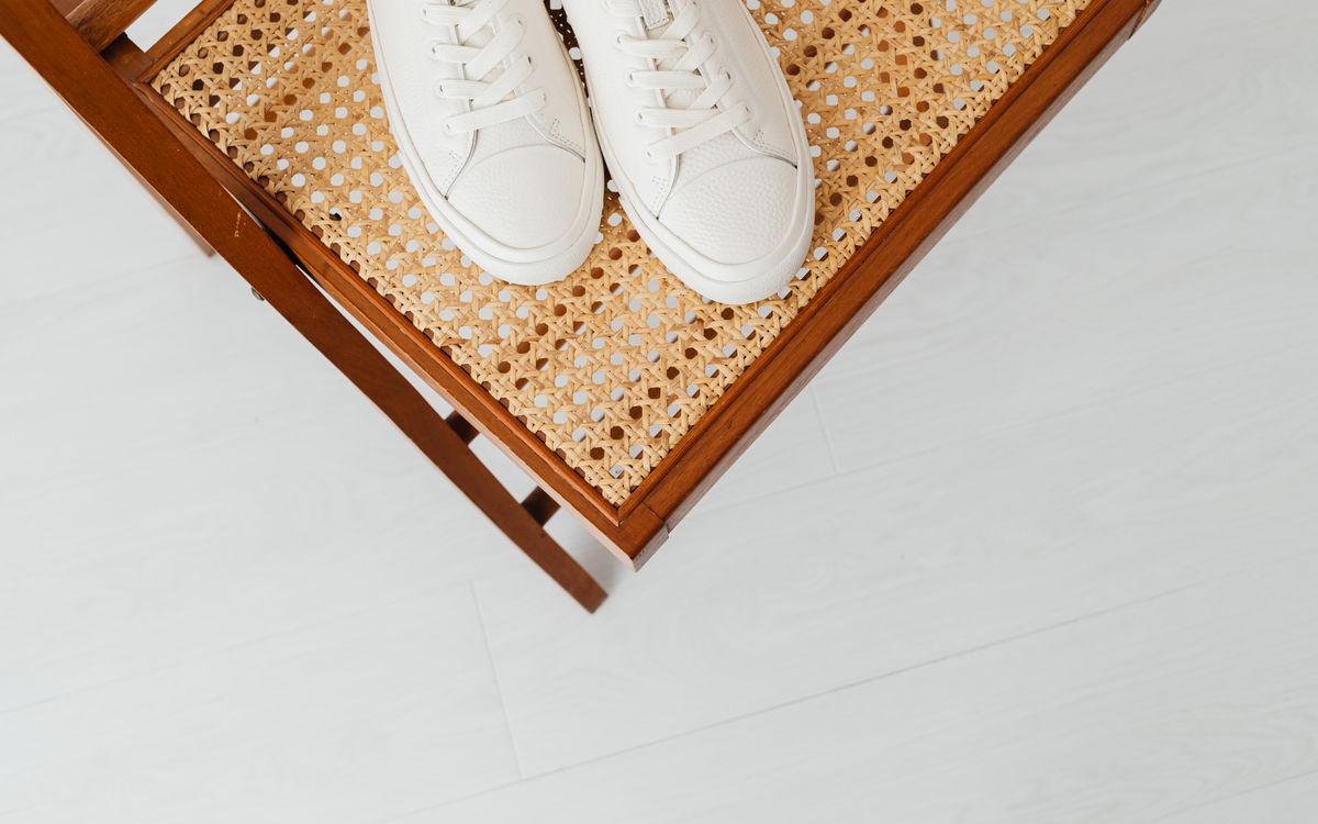 Sneaker bianche abbinate a un jeans casual su un marciapiede urbano