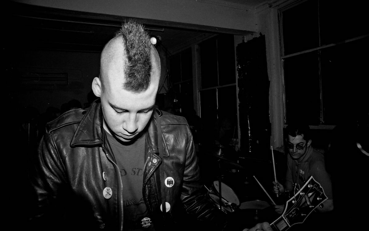 Una band punk che suona dal vivo, in bianco e nero