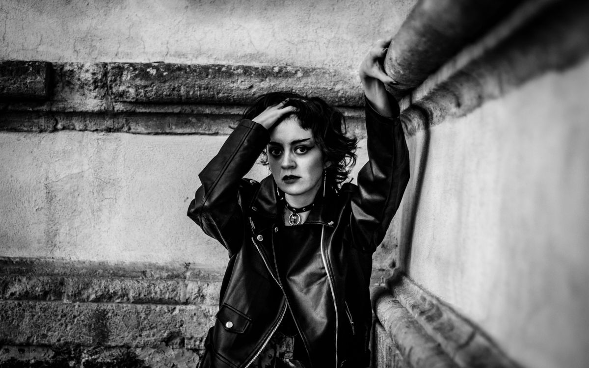 Ritratto in penombra di una persona con chiodo di pelle nera