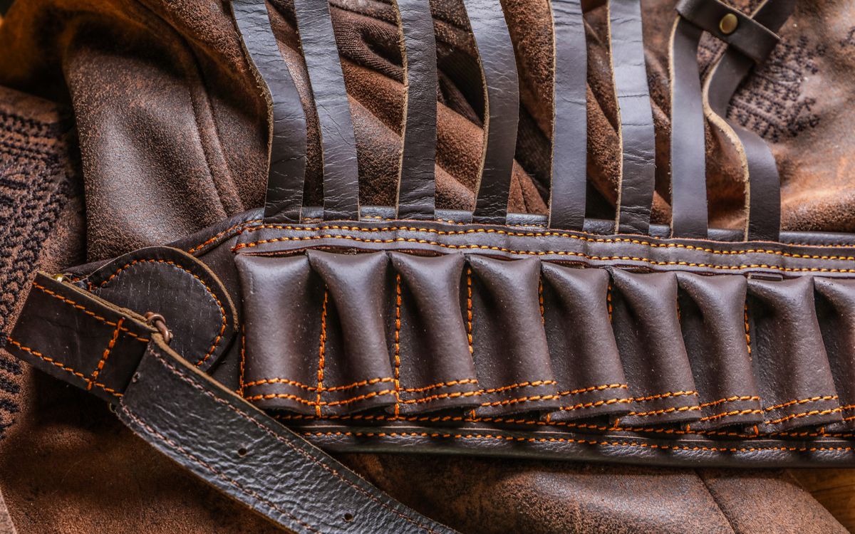 Primo piano di una giacca di pelle marrone con texture visibile e un dettaglio di cintura
