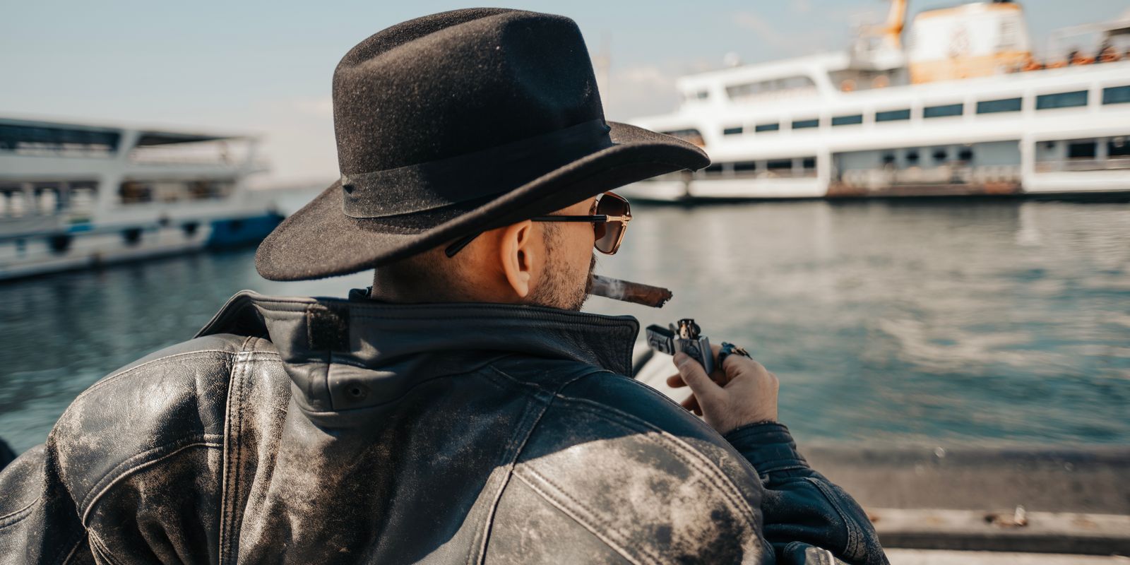 Un uomo con una giacca di pelle nera vintage e vissuta in una strada